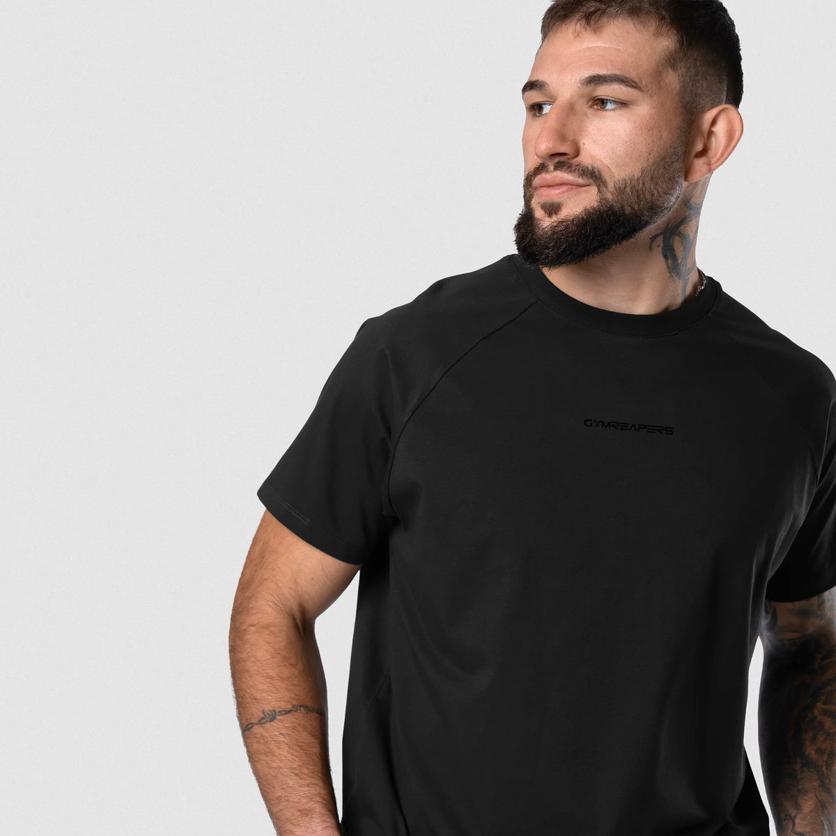 Male model wearing the Axis Raglan Tee - Black/Black angled view