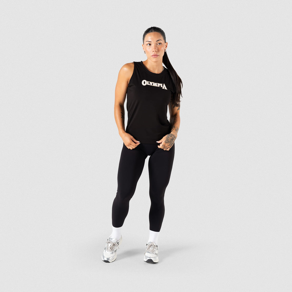 Full body view of the women's Champions Gold Full Length Training Tank paired with black leggings