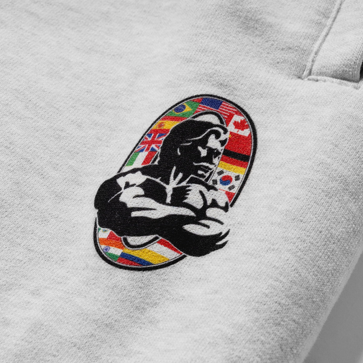Close up of the international flag Olympia bodybuilding logo below the pocket of the Olympia International Division Straight-Leg Jogger sweatpants