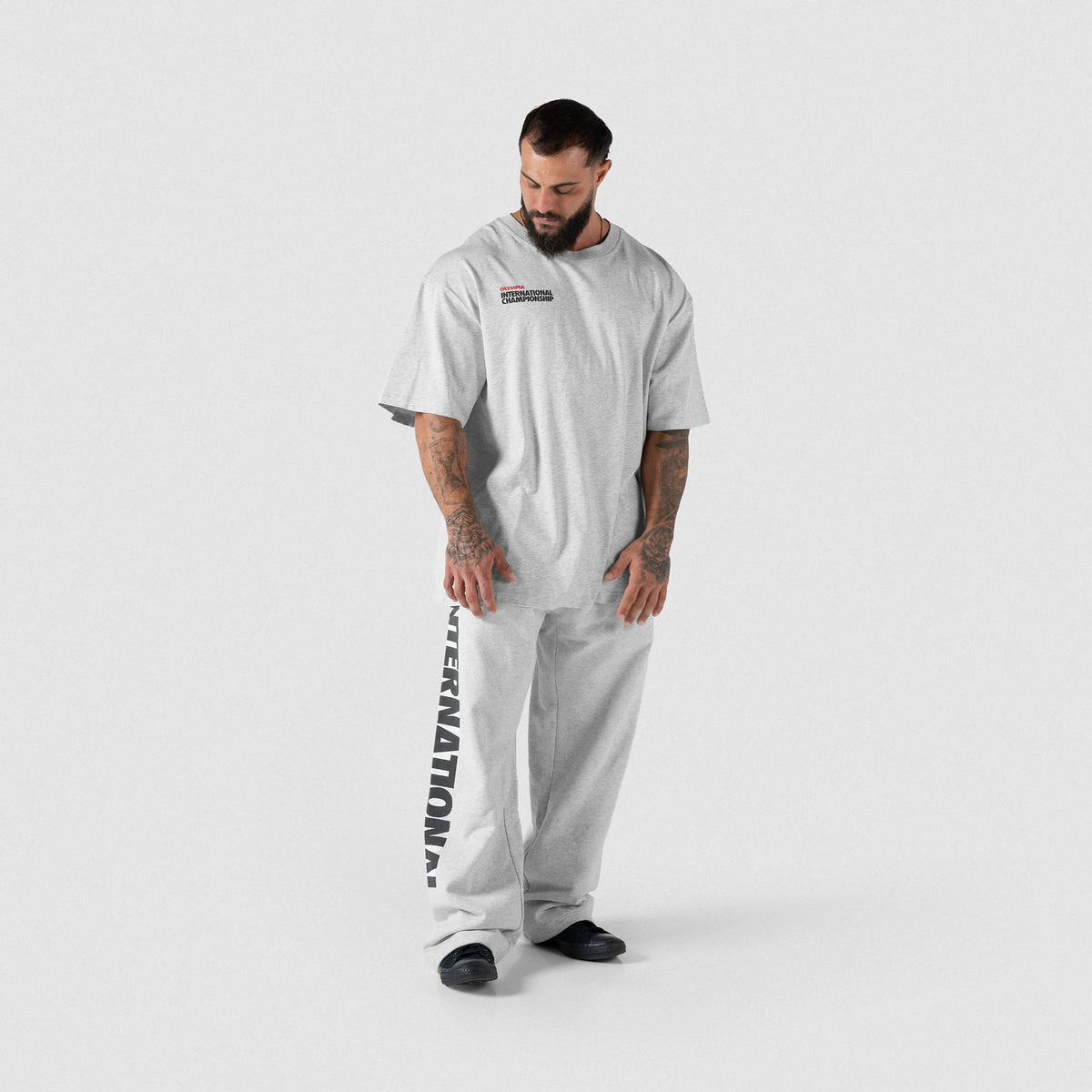Male model wearing the Olympia International Division Straight-Leg Jogger in gray with a matching gray t-shirt