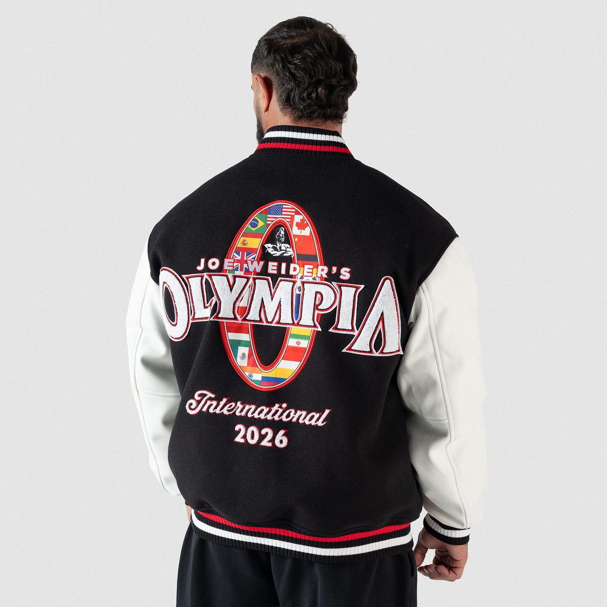 Olympia International Division Varsity Jacket in Black – On Model, Back View