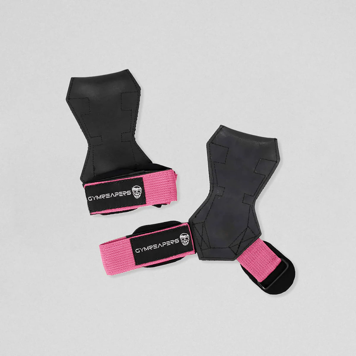 Gymreapers lifting grips pink one strap closed and the other laying flat and open.