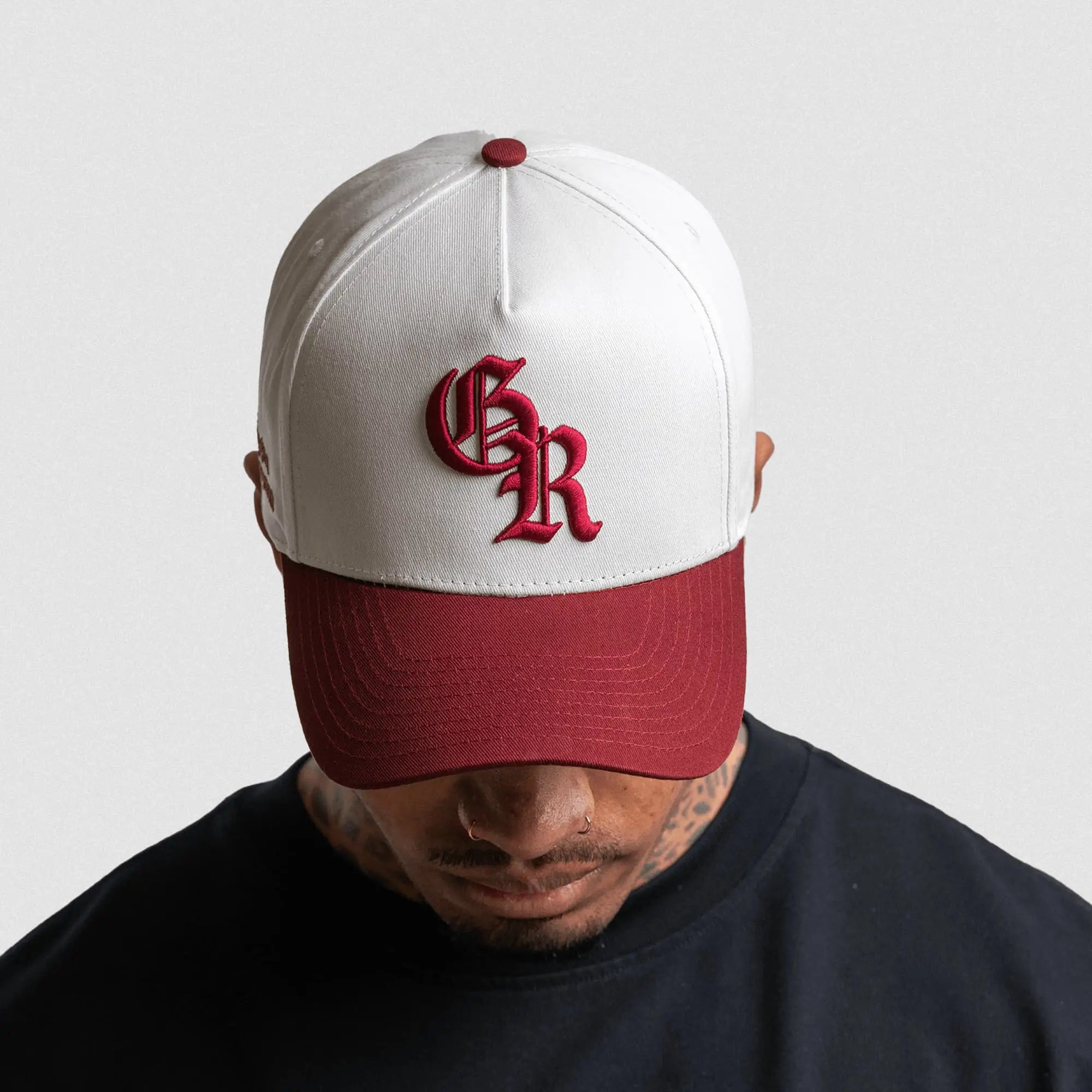 5 panel initial hat white maroon front on athlete gray background