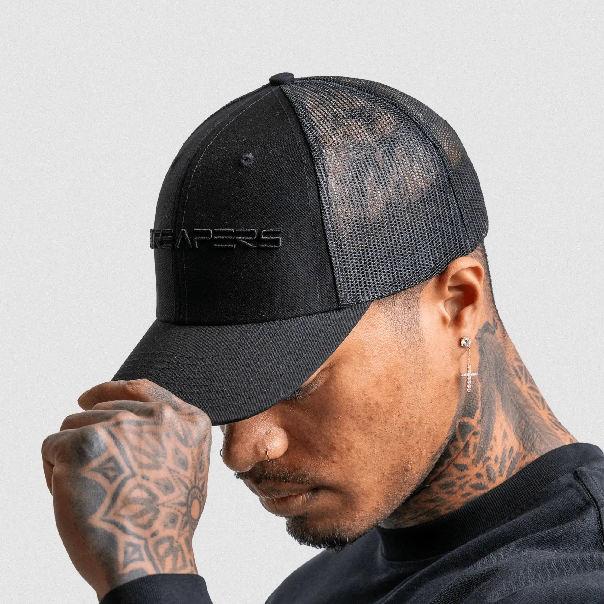 6 panel hat black black on athlete studio gray background side facing.