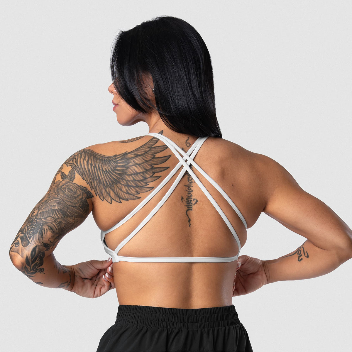 Female model wearing the Axis Open Back Bra - White open-back view