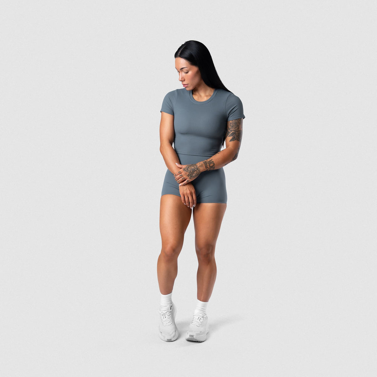 Female model wearing the Axis Support Baby Tee - Lake full-body view