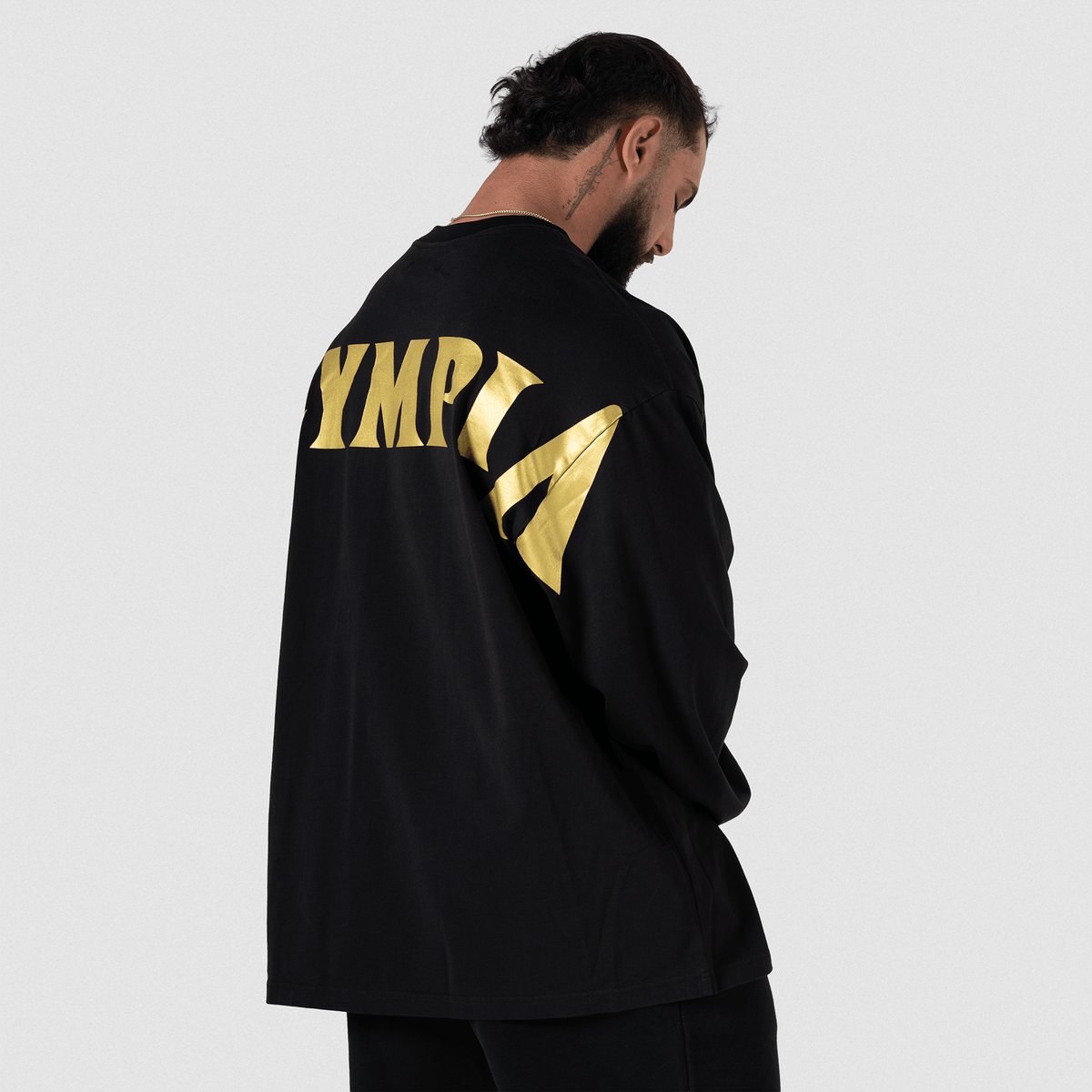 6. Man from behind showing gold "OLYMPIA" lettering on back, close-up angle
