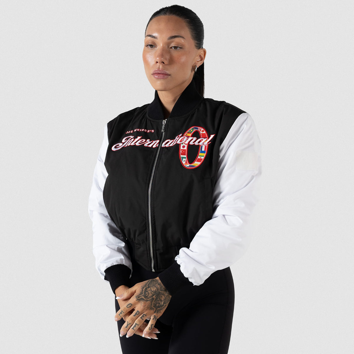 International Division Crop Bomber Jacket | On model, fully zipped black jacket with white sleeves
