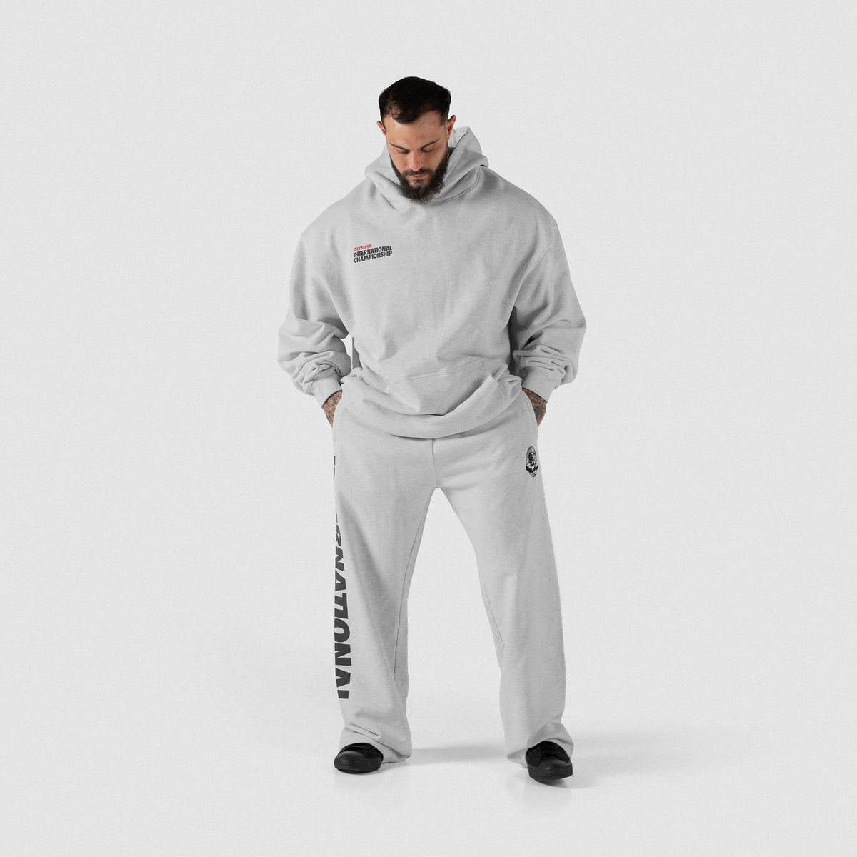 International Division Hoodie | Male model wearing the gray pullover with matching joggers facing forward