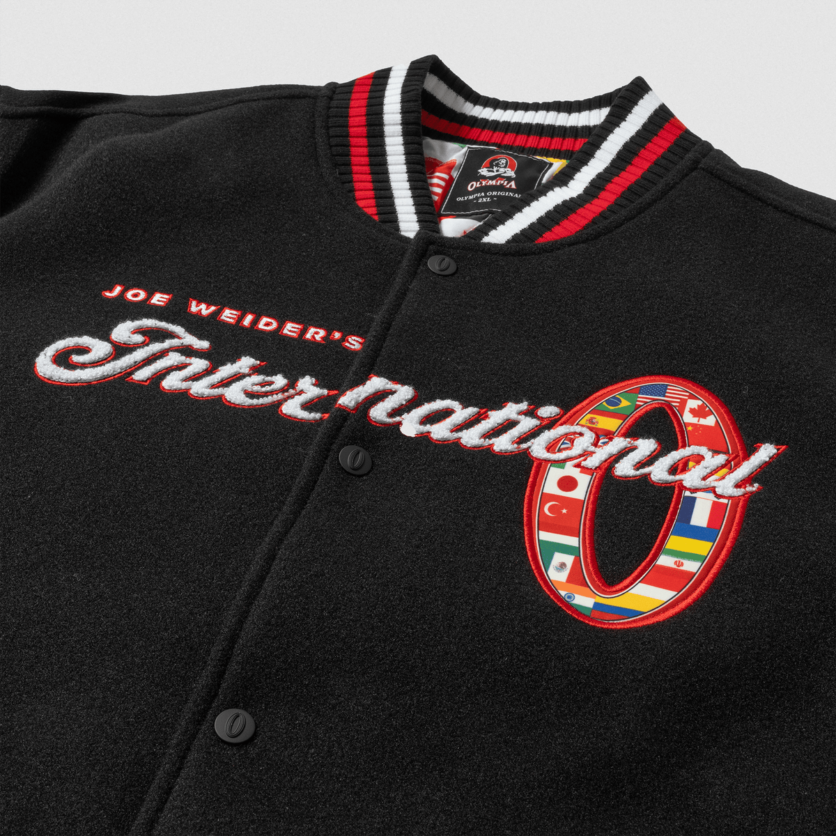 Olympia International Division Varsity Jacket in Black – "International" Script Chest Embroidery Detail