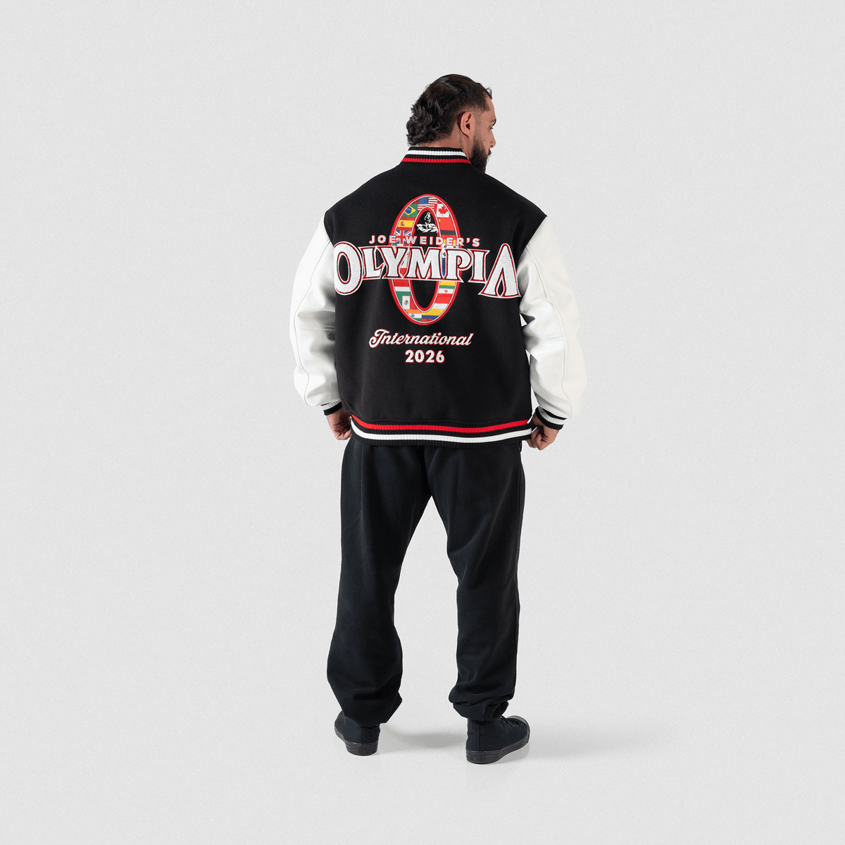 Olympia International Division Varsity Jacket in Black – Full Body On Model, Back View