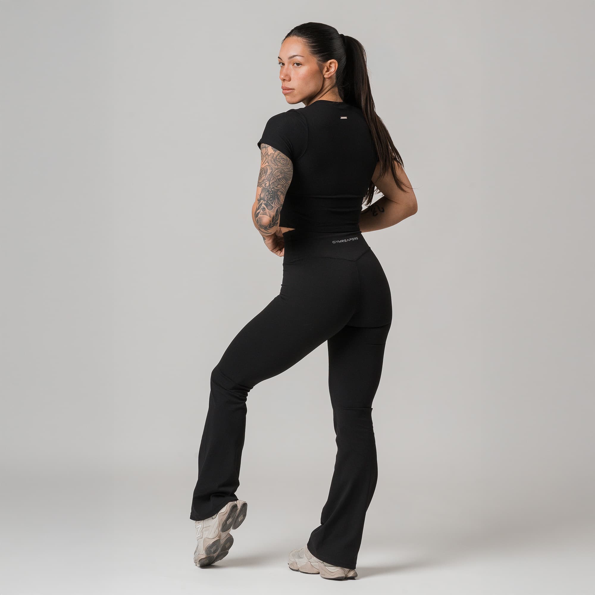 athlete wearing black axis flare leggings full body shot back view