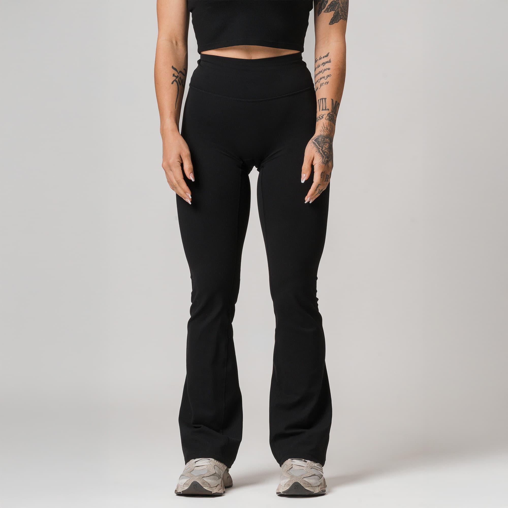 athlete wearing black axis flare leggings half body shot front view