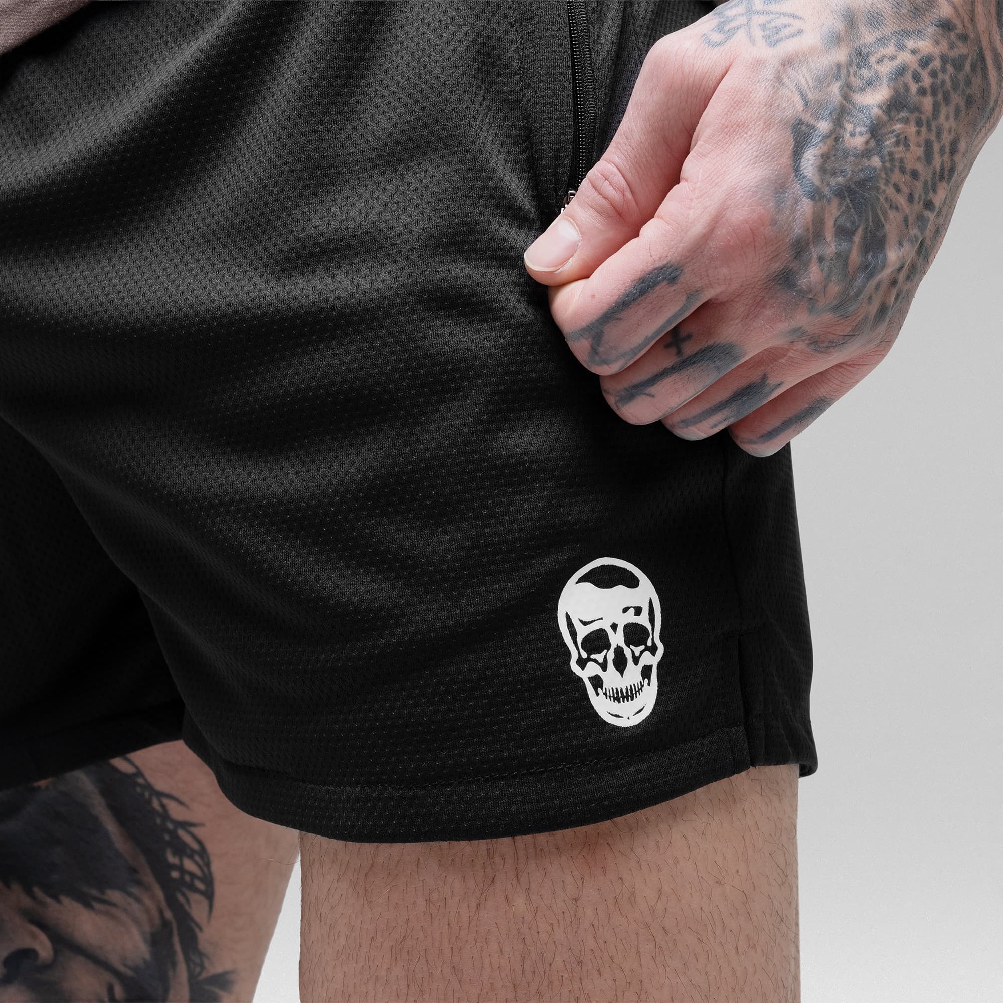 Athlete wearing the Black/White Core Skull Mesh Training Shorts detail shot of pocket and logo