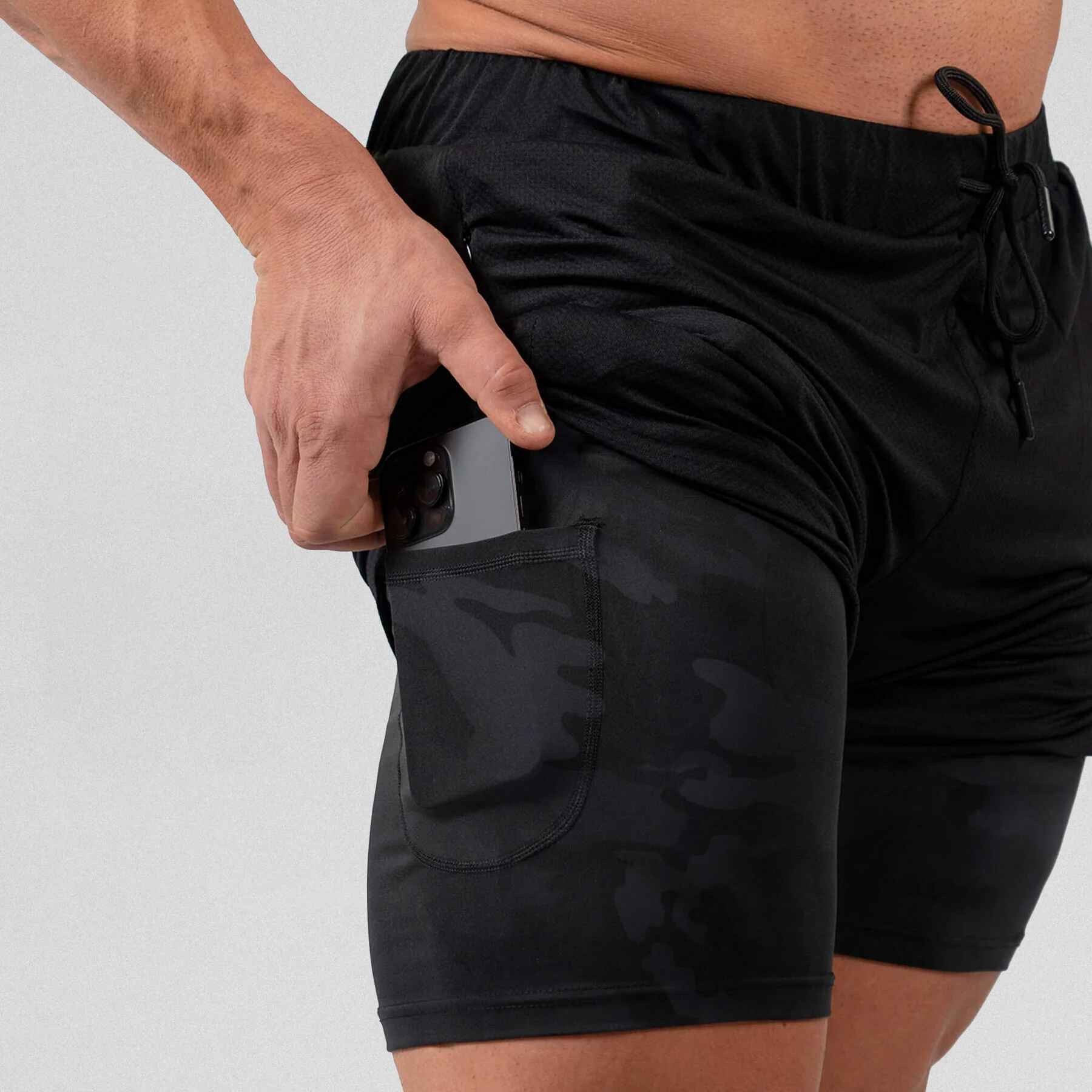 Gymreapers react training shorts black camo with athlete wearing them, zoomed in to hidden pocket side on liner.