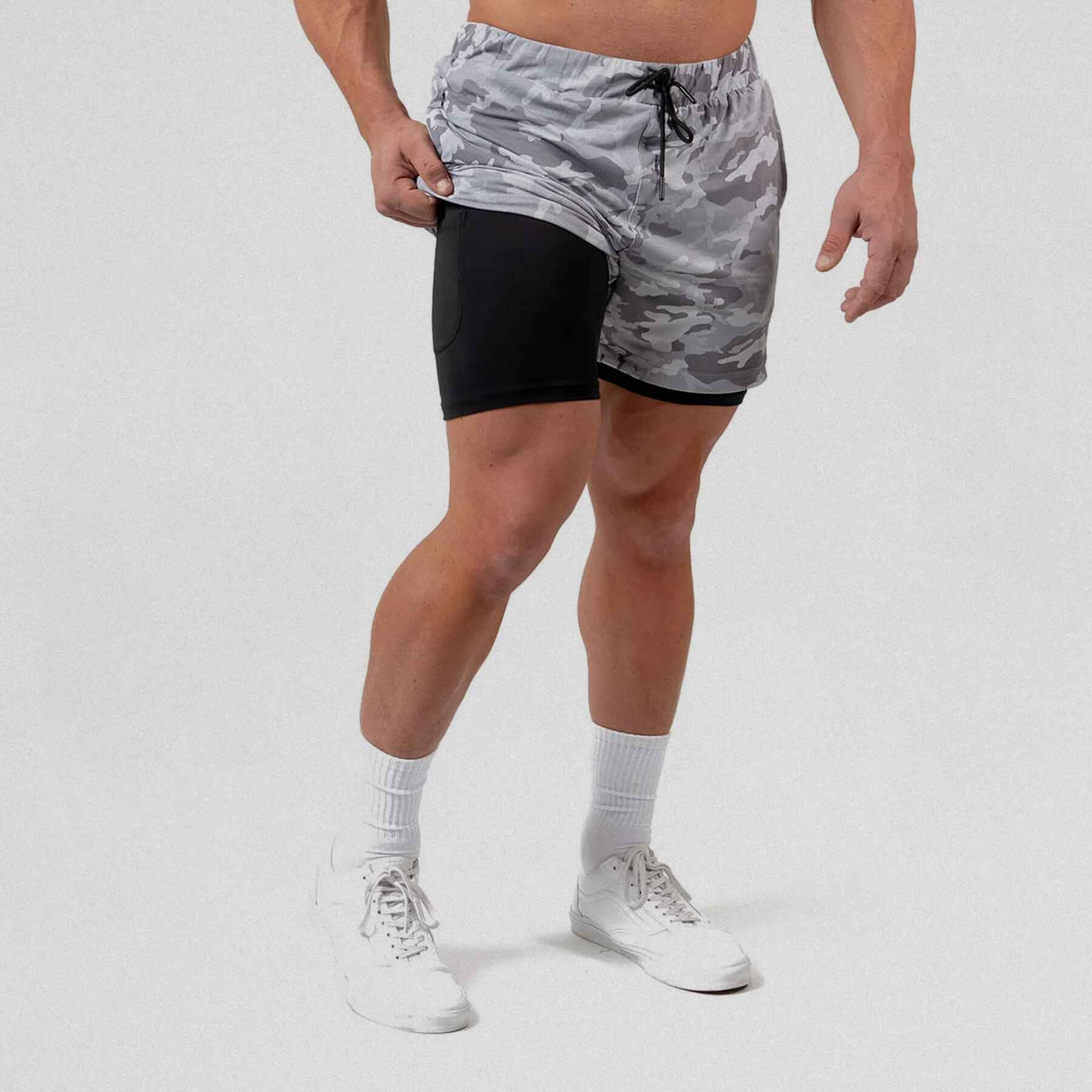 React training shorts white camo color way on athlete holding the side up to show liner.