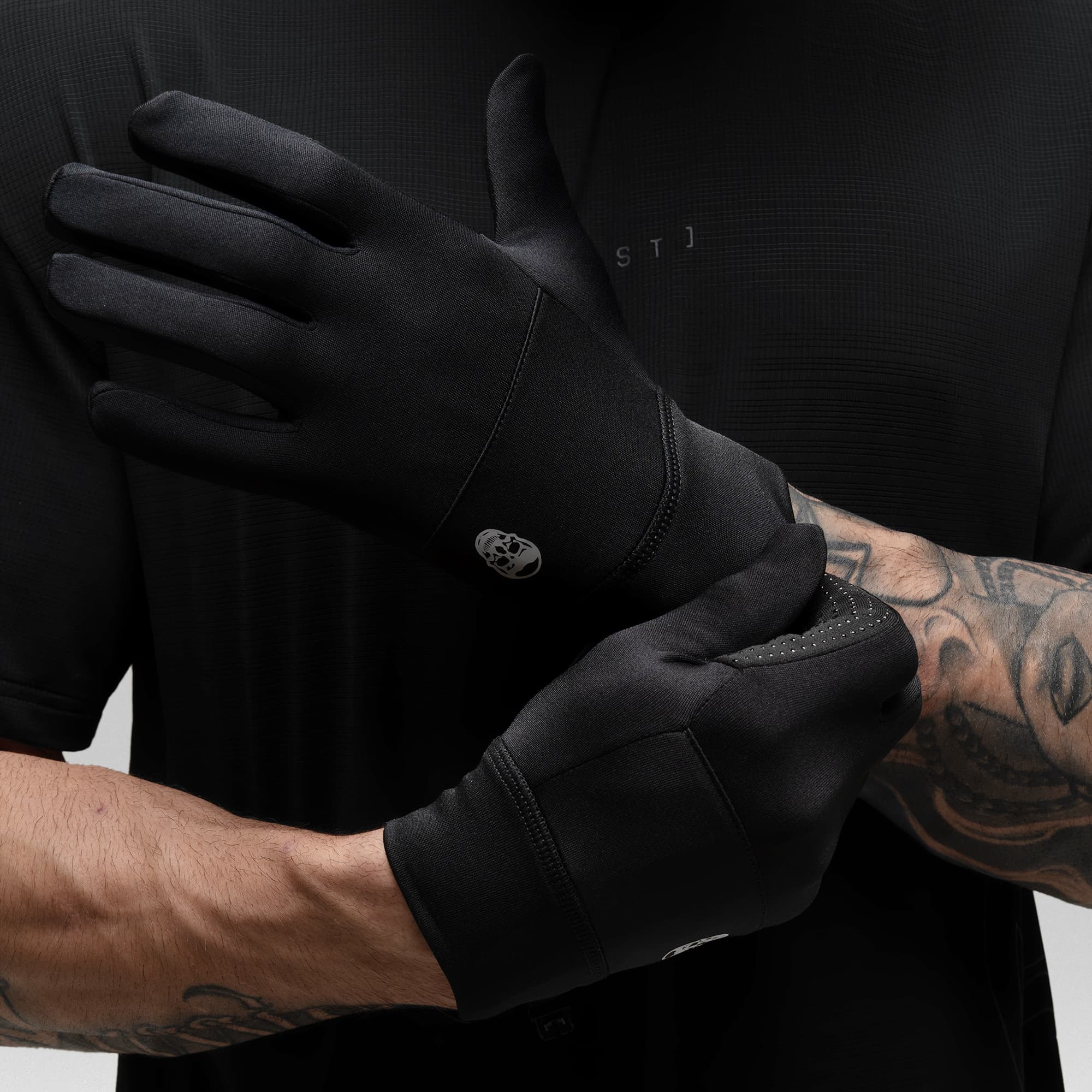 Model putting on the Black Stryda™ Run Gloves