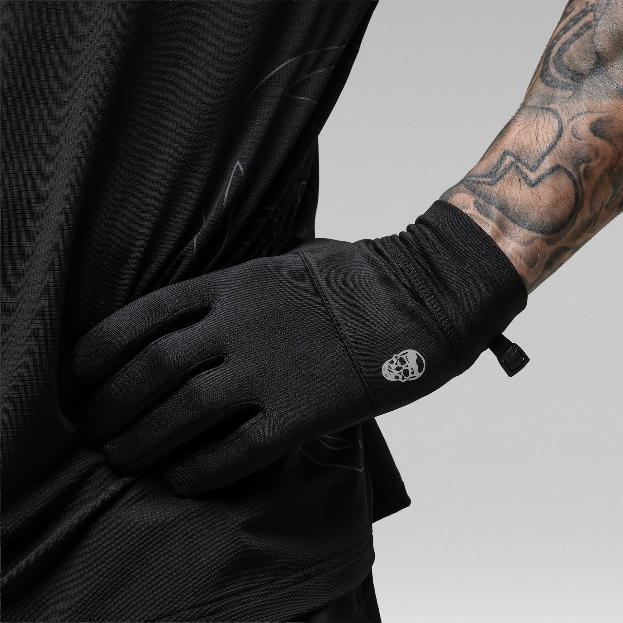 Model wearing the Black Stryda™ Run Gloves with hand on waist